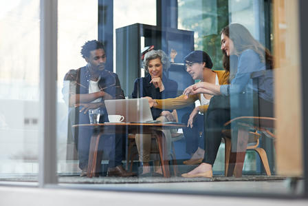 IT specialists advising clients in a conference room.